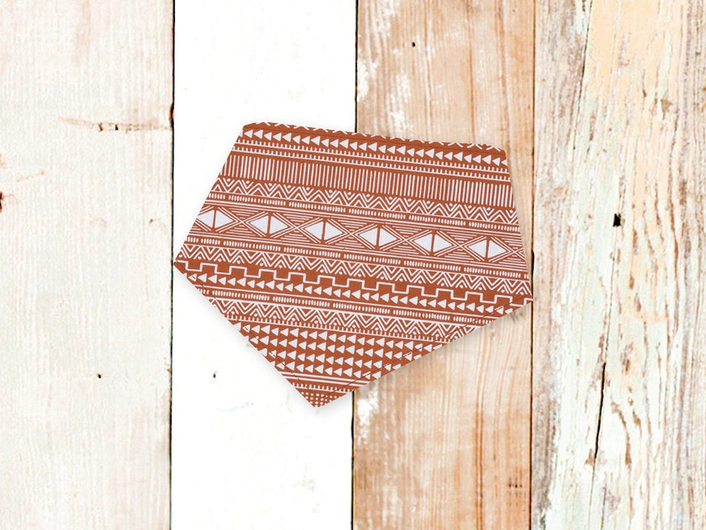 Coral Aztec Patterned dog bandana on a wooden background